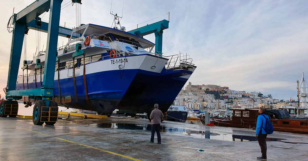 Grúa "travelift" en movimiento, transportando la embarcación Ulises Cat de Sea Experience Ibiza