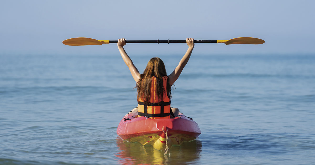 mujer en un kayak en el mar